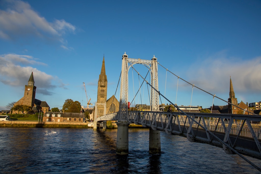 A view of the city of Inverness - a bridge, and two towers are visible across the River Ness