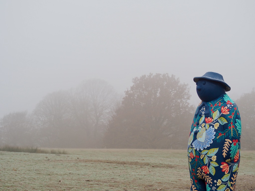 A blue snowman stares wistfully into the mist